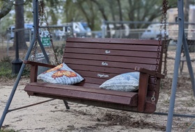 double wooden swing with pillows