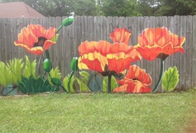 a wooden privacy fence custom painted with bright flowers